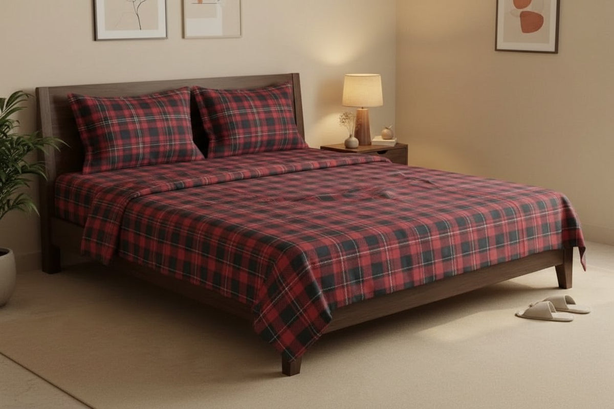 Highland Tartan Double Bedsheet Set with bold crimson red and charcoal tartan plaid print, styled on a dark wood double bed with two matching pillow covers