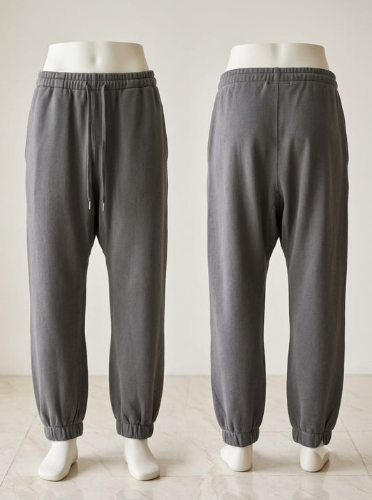 Front and back views of grey jogger trousers with a drawstring waist, side pockets, and gathered ankle cuffs