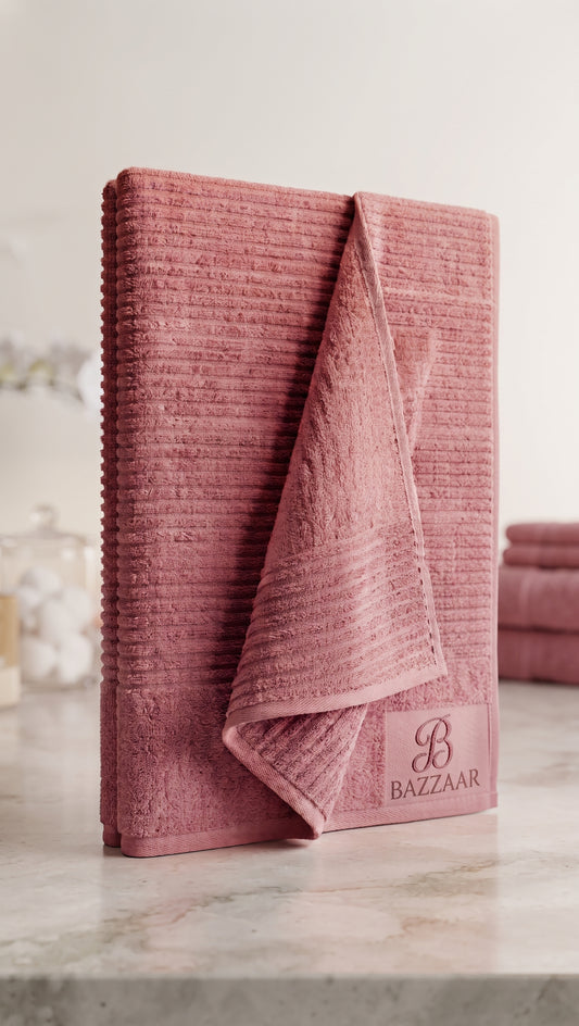 Dusty pink textured Bazzaar towel folded upright with horizontal lines