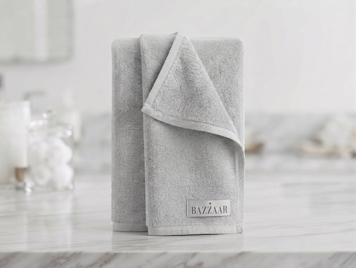 Light grey textured Bazzaar towel folded upright with finished border
