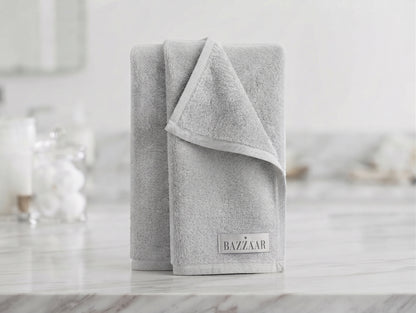 Light grey textured Bazzaar towel folded upright with finished border