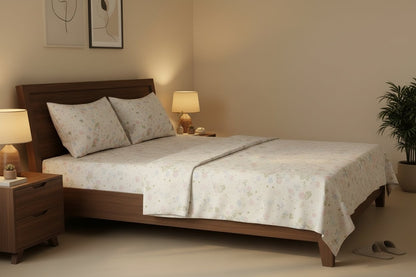 Meadow Whisper King Bedsheet Set with delicate scattered pastel wildflower print in pink, blue and sage green on white, styled on a dark wood king bed with two matching pillow covers
